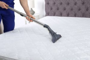 man-in-blueuniform-cleaning-mattress